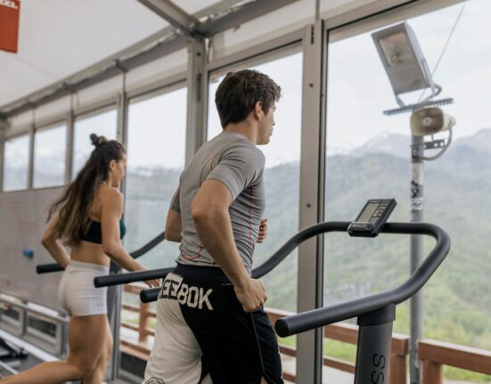 Person doing cardio exercises in gym on treadmill