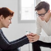 A person practicing daily depression support tips like journaling and drinking herbal tea in a bright room.