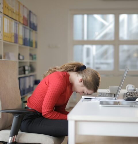 A person practicing effective stress management techniques like deep breathing and herbal tea consumption