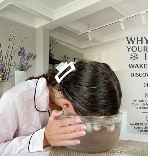 Close-up of a person applying cold water treatment to reduce puffy eyes and refresh tired eyes naturally at home.